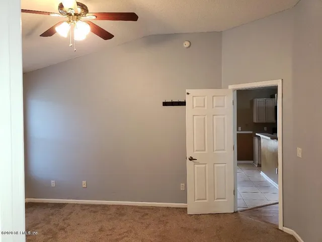 an empty room with windows and fan