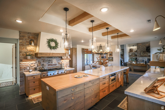 6688 Bareback Road Cedar City, UT 84720 - Photo 58 of 58 Kitchen featuring beamed ceiling, a fireplace, decorative light fixtures, open floor plan, and stainless steel appliances