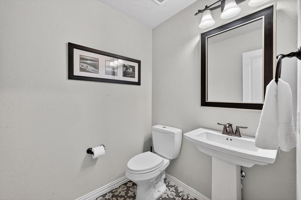 6656 Roughleaf Ridge Road Flower Mound, TX 76226 - Photo 30 of 40 a bathroom with a toilet sink and mirror