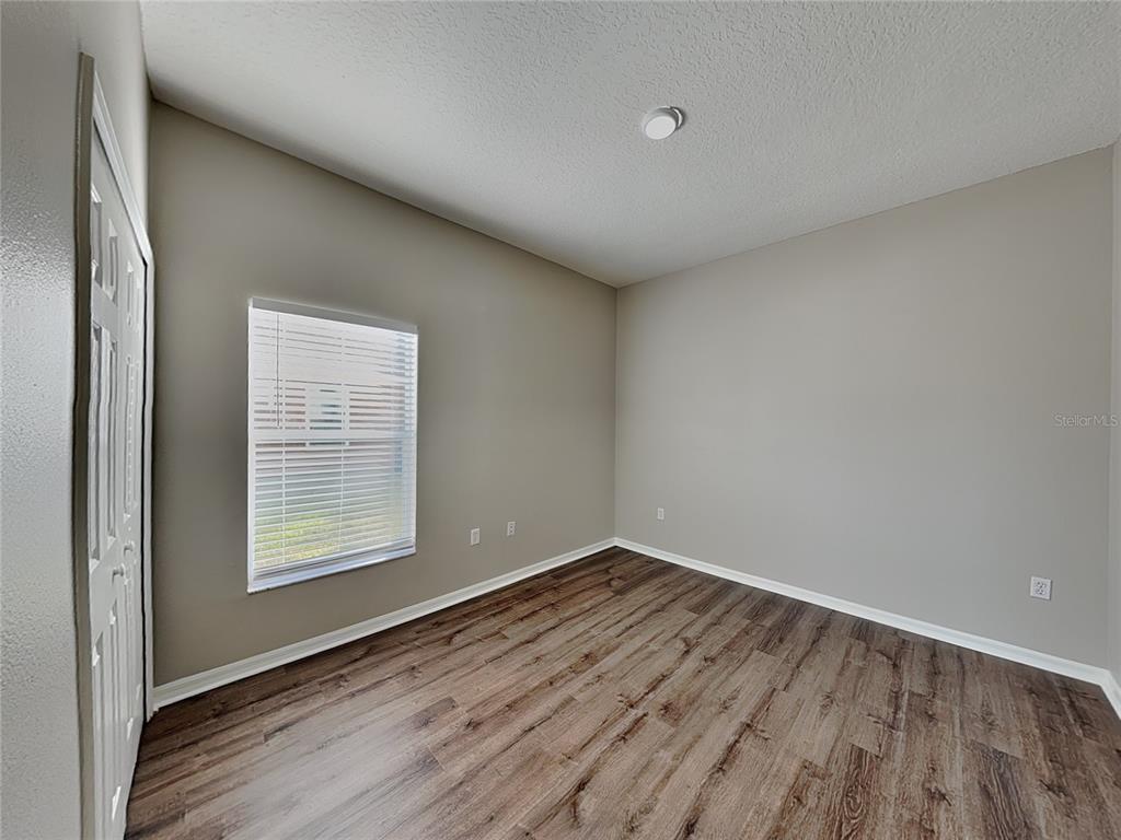 Undisclosed Address Land O' Lakes, FL 34639 - Photo 15 of 25 an empty room with wooden floor and windows