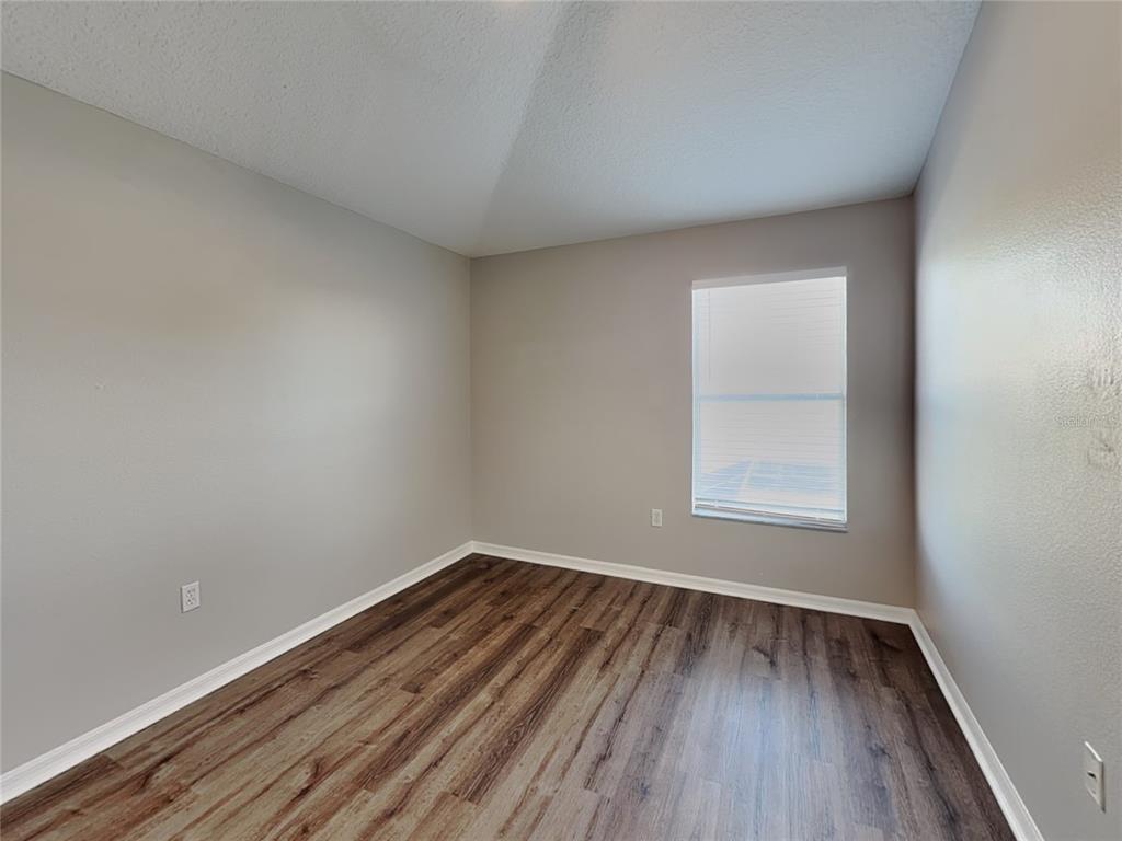 Undisclosed Address Land O' Lakes, FL 34639 - Photo 19 of 25 an empty room with wooden floor and windows