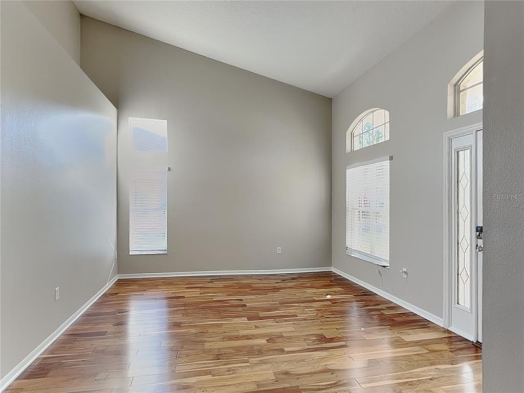 Undisclosed Address Land O' Lakes, FL 34639 - Photo 2 of 25 an empty room with wooden floor and windows