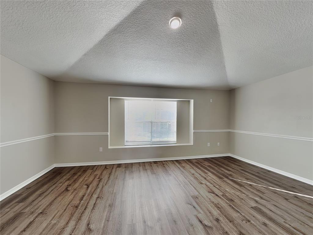 Undisclosed Address Land O' Lakes, FL 34639 - Photo 6 of 25 an empty room with wooden floor and windows