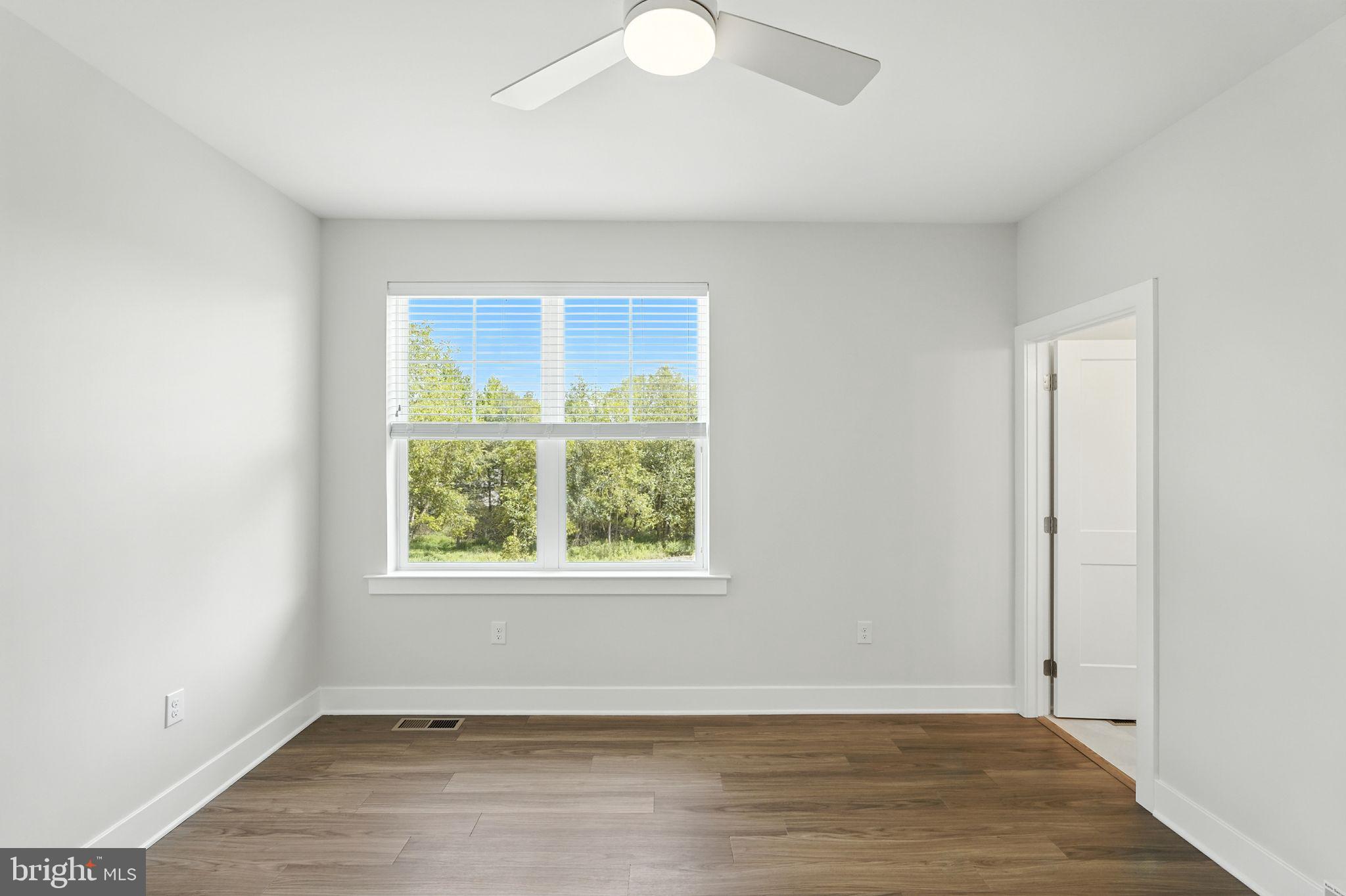 17 Mainland Road, Unit 115 Harleysville, PA 19438 - Photo 12 of 15 an empty room with wooden floor and windows