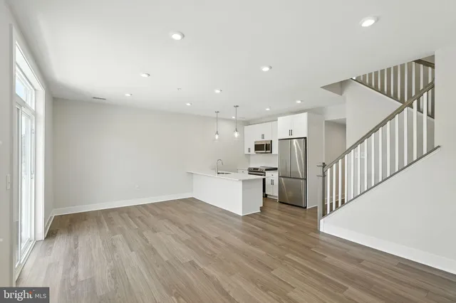 a view of a kitchen with wooden floor and electronic appliances