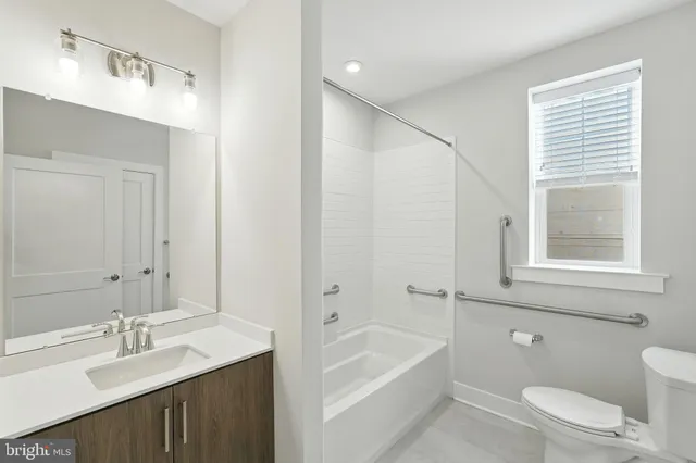 a bathroom with a granite countertop sink a toilet and shower