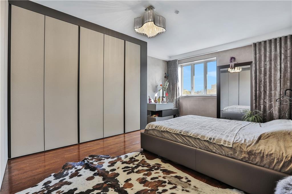 3392 Guider Avenue, Unit 8 Brooklyn, NY 11235 - Photo 13 of 22 a bedroom with a bed and wooden floor