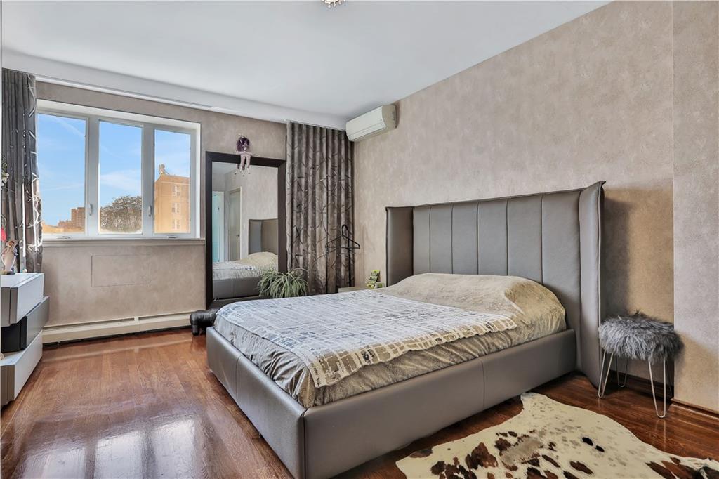 3392 Guider Avenue, Unit 8 Brooklyn, NY 11235 - Photo 14 of 22 a bedroom with a large bed and a dresser