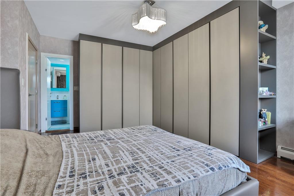 3392 Guider Avenue, Unit 8 Brooklyn, NY 11235 - Photo 16 of 22 a bedroom with a large bed and a chandelier