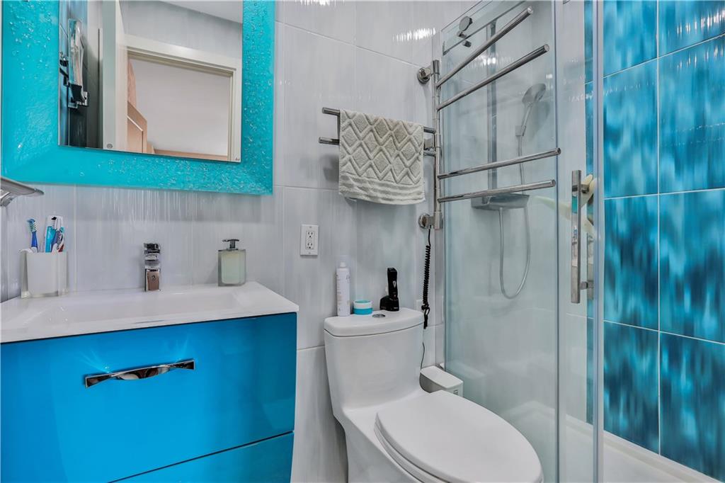 3392 Guider Avenue, Unit 8 Brooklyn, NY 11235 - Photo 17 of 22 a bathroom with a sink a toilet and shower