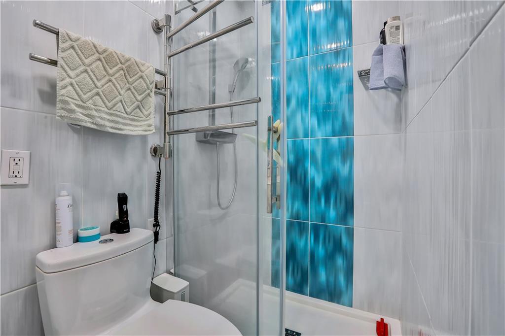 3392 Guider Avenue, Unit 8 Brooklyn, NY 11235 - Photo 18 of 22 a bathroom with a shower and toilet