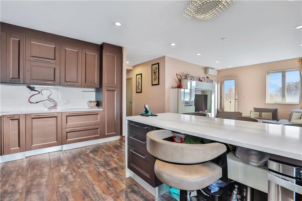 3392 Guider Avenue, Unit 8 Brooklyn, NY 11235 - Photo 7 of 22 a kitchen with kitchen island a stove a sink and a refrigerator