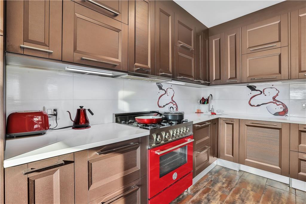 3392 Guider Avenue, Unit 8 Brooklyn, NY 11235 - Photo 9 of 22 a kitchen with stainless steel appliances granite countertop a sink dishwasher stove and cabinets with wooden floor