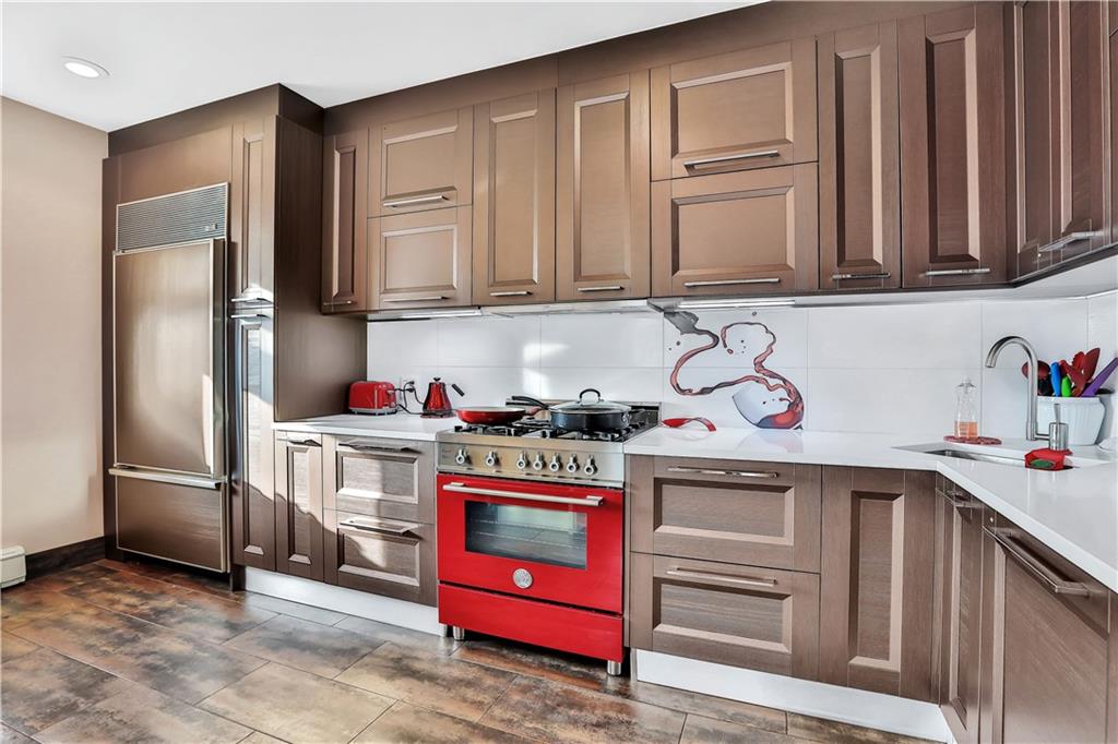3392 Guider Avenue, Unit 8 Brooklyn, NY 11235 - Photo 10 of 22 a kitchen with stainless steel appliances granite countertop a refrigerator stove and sink