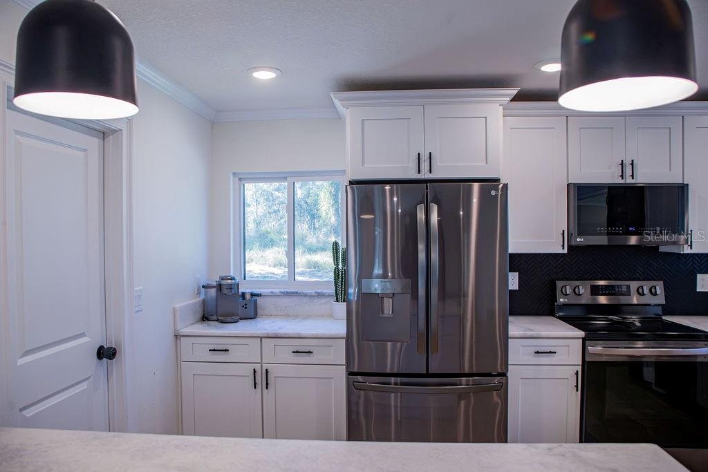 336 Lake Mabel Loop Road Lake Wales, FL 33898 - Photo 21 of 60 a kitchen with kitchen island a counter space a sink appliances and cabinets