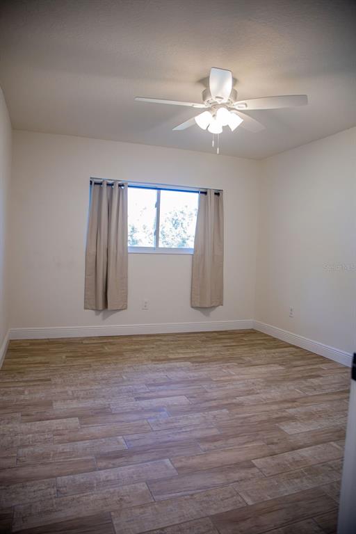 336 Lake Mabel Loop Road Lake Wales, FL 33898 - Photo 33 of 60 a view of an empty room with wooden floor and a window