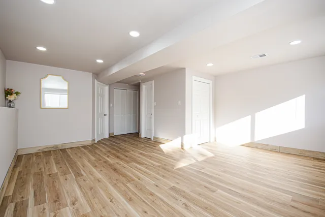 a view of empty room with wooden floor