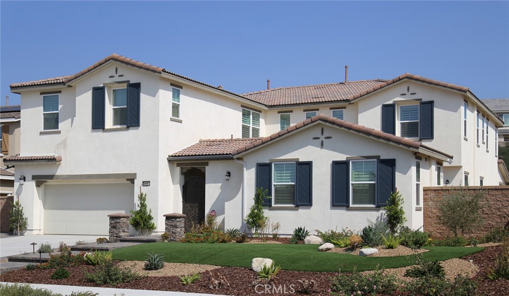 a front view of a house with a yard and potted plants