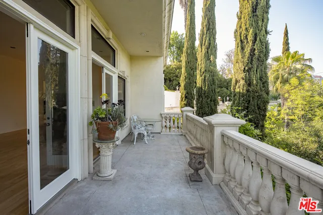 a view of a patio with chairs and potted plants