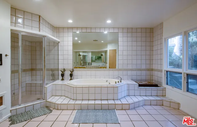 a bathroom with a large tub shower and checkered floor