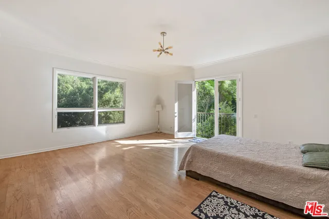 a bedroom with a bed and a large window