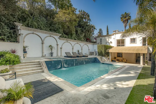 a view of a white house with a yard and sitting area