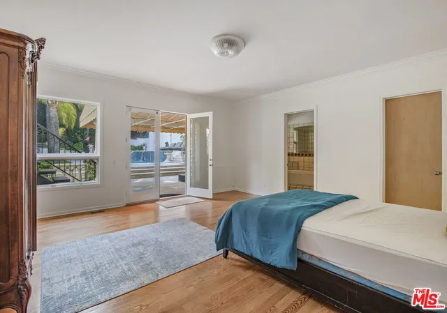 a living room with a bed furniture and next to a window