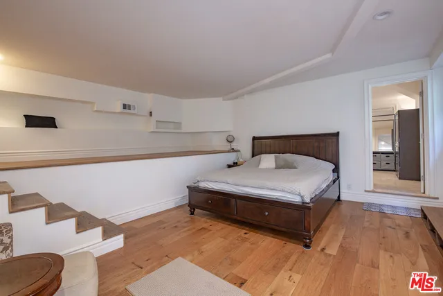 a spacious bedroom with a bed and a dresser