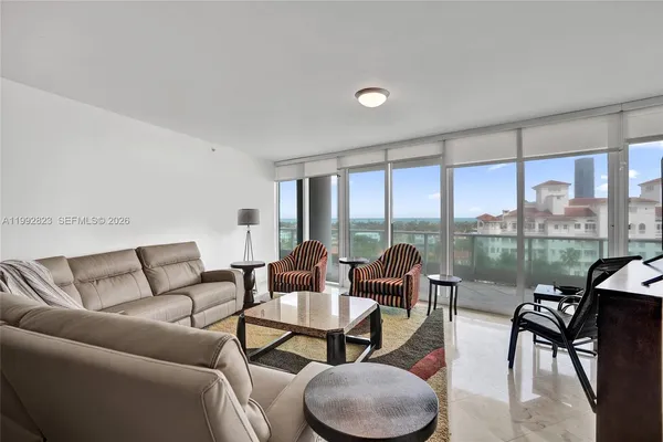 a living room with furniture and a floor to ceiling window