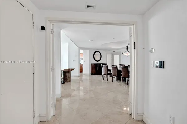 a view of a dining room and livingroom with furniture a fireplace and a chandelier