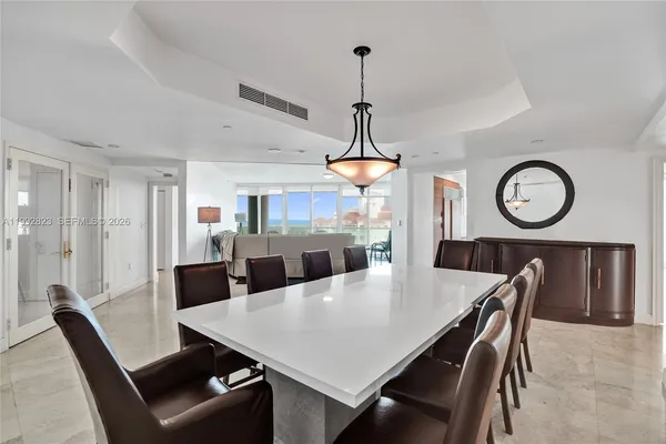 a kitchen with stainless steel appliances granite countertop a stove top oven a sink dishwasher a dining table and chairs with wooden floor