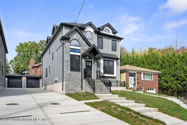 a front view of a house with a garden and trees