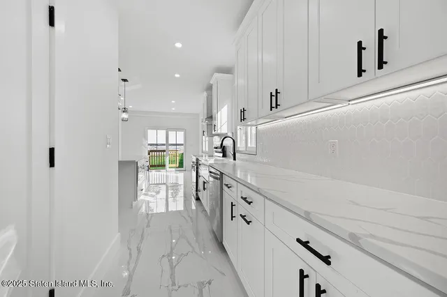 a kitchen with granite countertop a white stove top oven and white cabinets