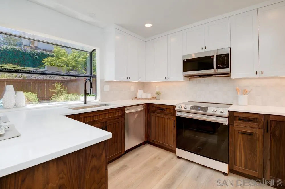 721 Summersong Lane Encinitas, CA 92024 - Photo 13 of 29 a kitchen with stainless steel appliances granite countertop a stove a microwave and a sink