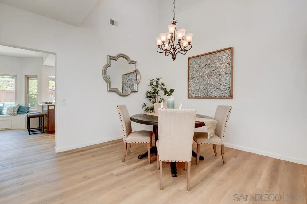 721 Summersong Lane Encinitas, CA 92024 - Photo 5 of 29 a dining room with furniture wooden floor a chandelier and a mirror
