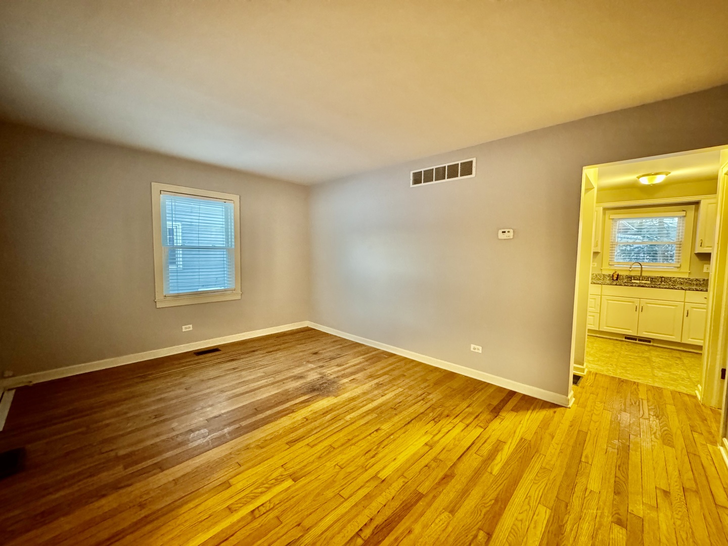 28 Batavia Road Warrenville, IL 60555 - Photo 3 of 17 a view of an empty room with wooden floor and a window