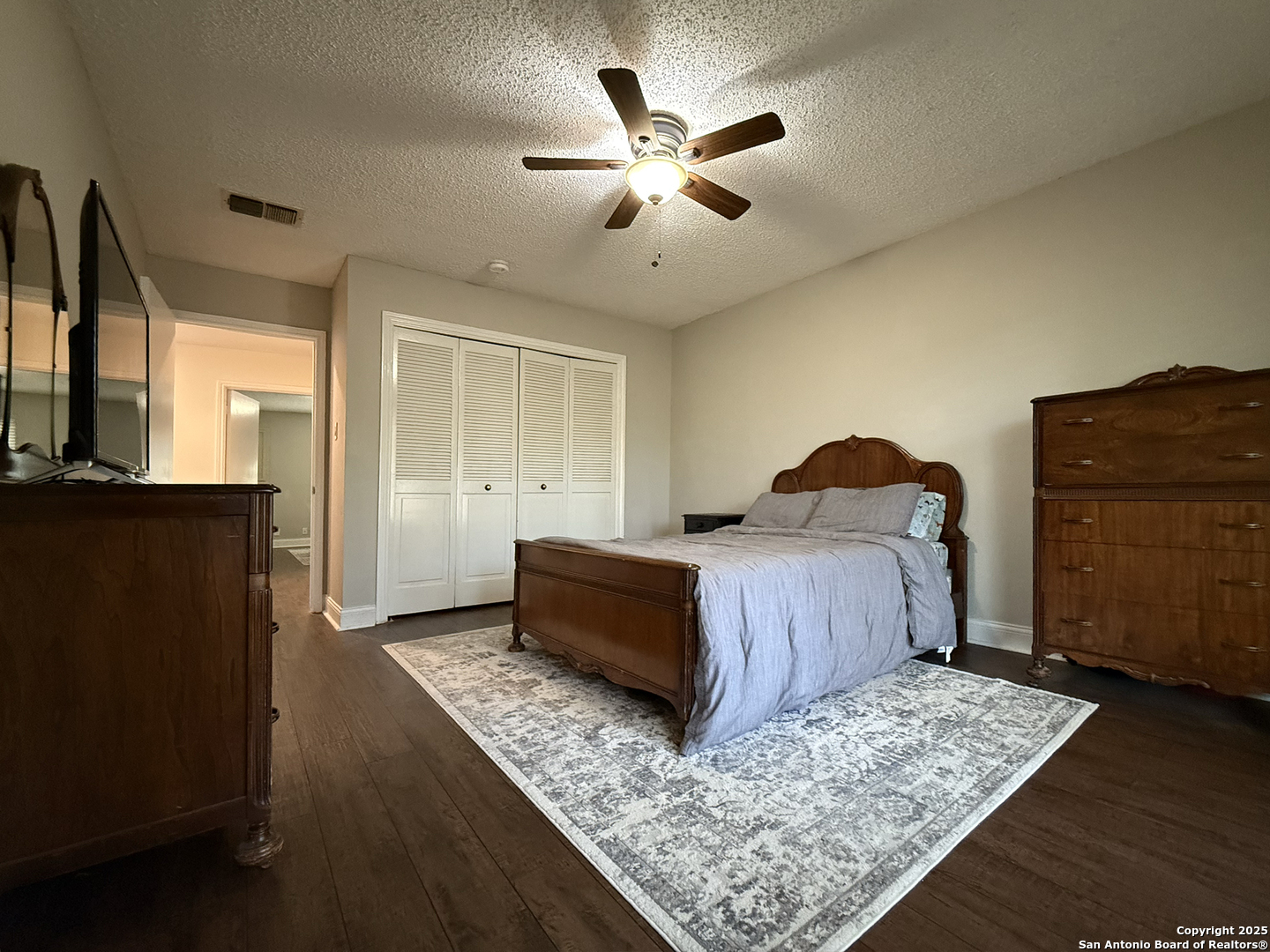 12518 Chateau Forest Lane San Antonio, TX 78230 - Photo 18 of 37 a bedroom with a bed and wooden floor