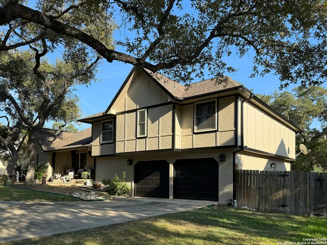 a view of a house with a yard balcony and tree