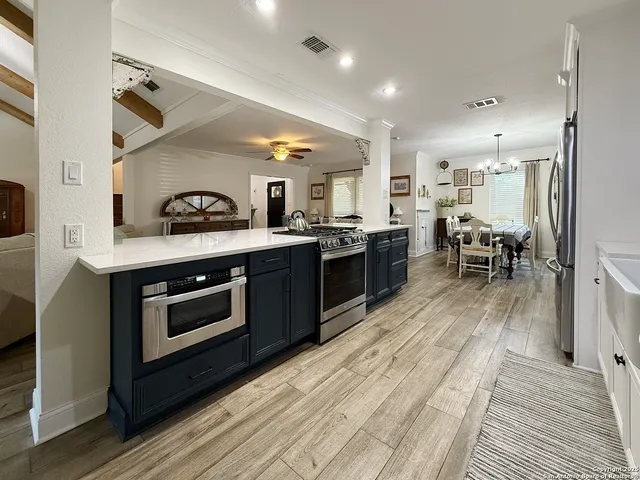 a view of a dining room with furniture a rug and wooden floor