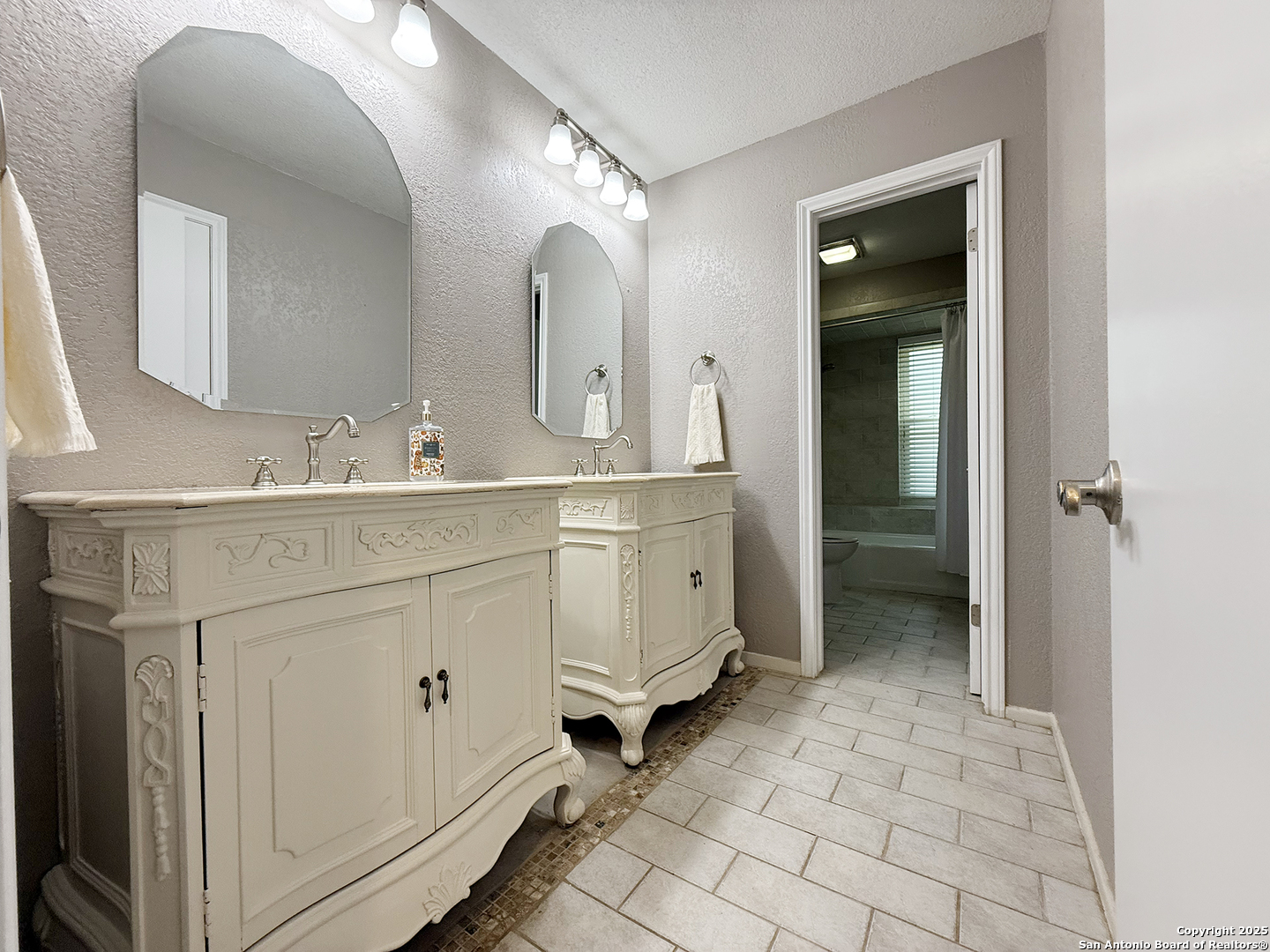 12518 Chateau Forest Lane San Antonio, TX 78230 - Photo 36 of 37 a spacious bathroom with a double vanity sink a mirror and a shower