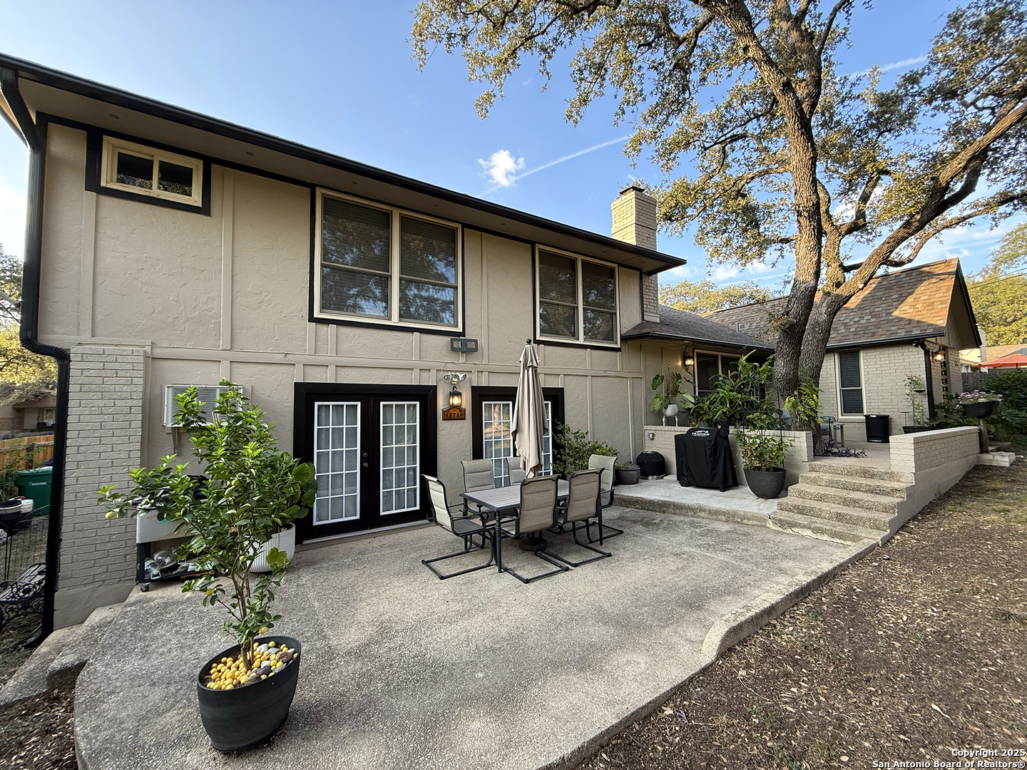 12518 Chateau Forest Lane San Antonio, TX 78230 - Photo 6 of 37 a view of a patio with table and chairs potted plants and a large tree