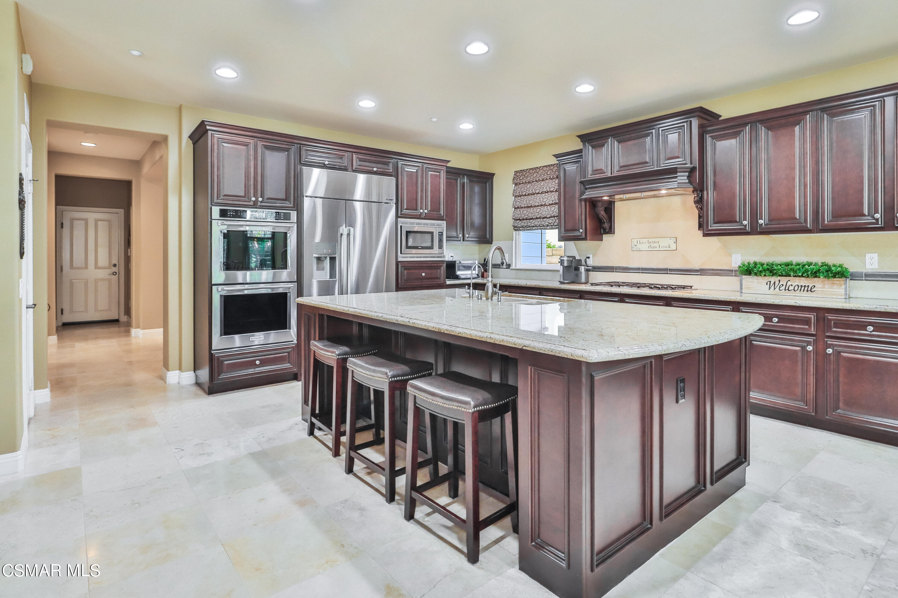 4025 Eagle Flight Drive Simi Valley, CA 93065 - Photo 11 of 60 a kitchen with stainless steel appliances granite countertop a table chairs sink and refrigerator