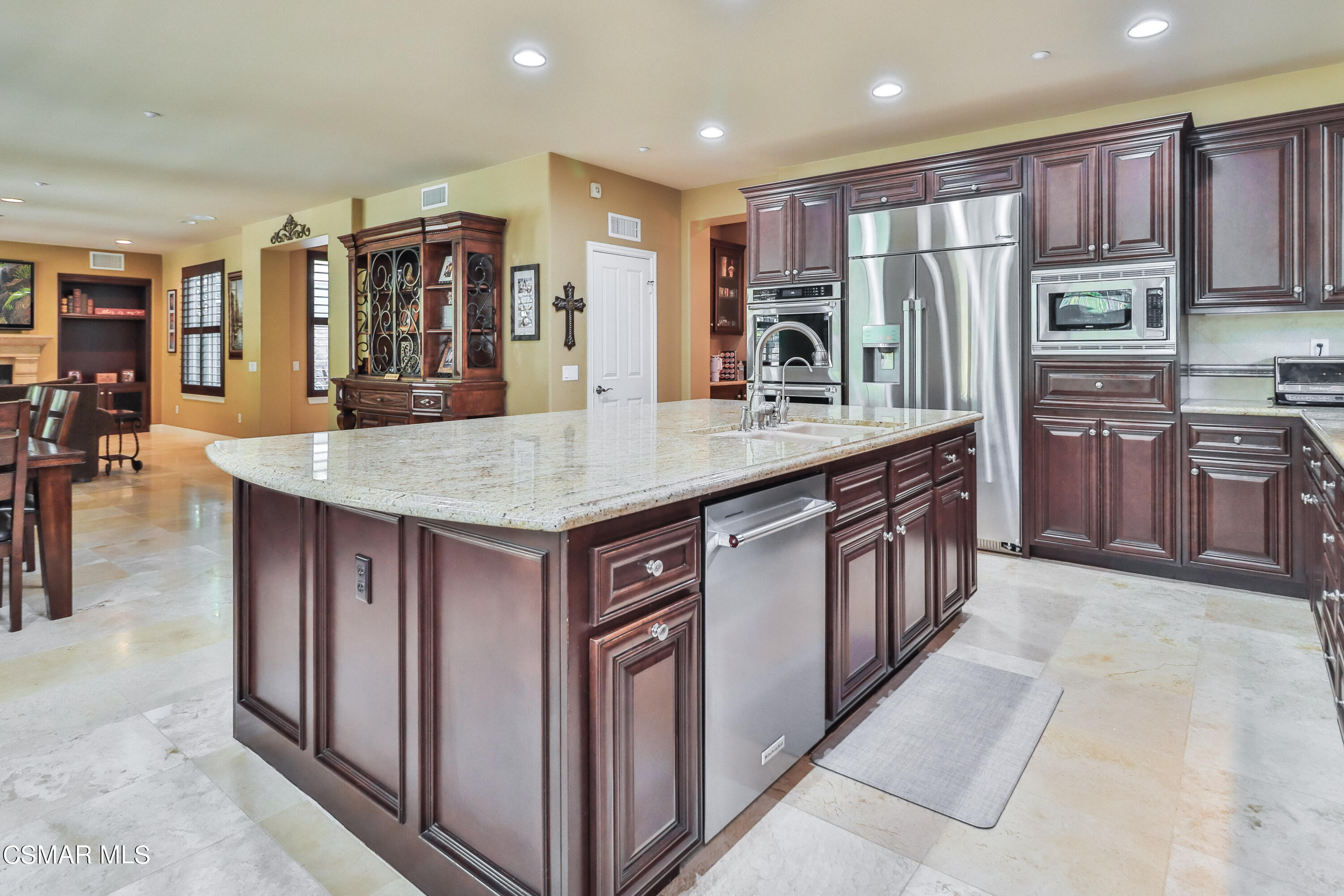 4025 Eagle Flight Drive Simi Valley, CA 93065 - Photo 13 of 60 a kitchen with stainless steel appliances granite countertop a table chairs sink refrigerator and cabinets