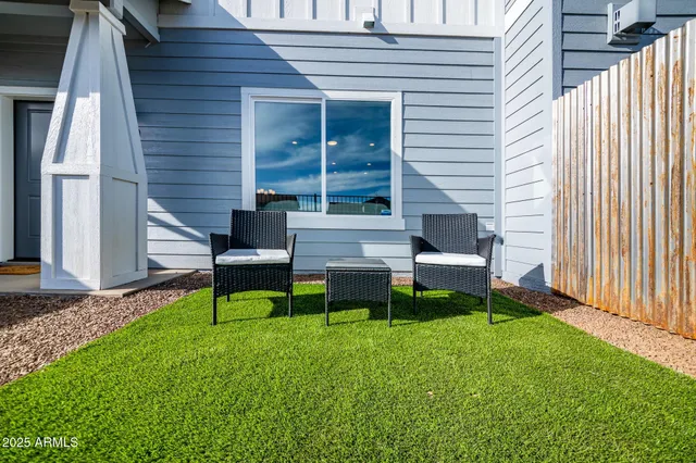 a view of house with backyard and a sitting area