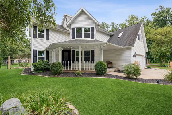a front view of a house with plants and garden