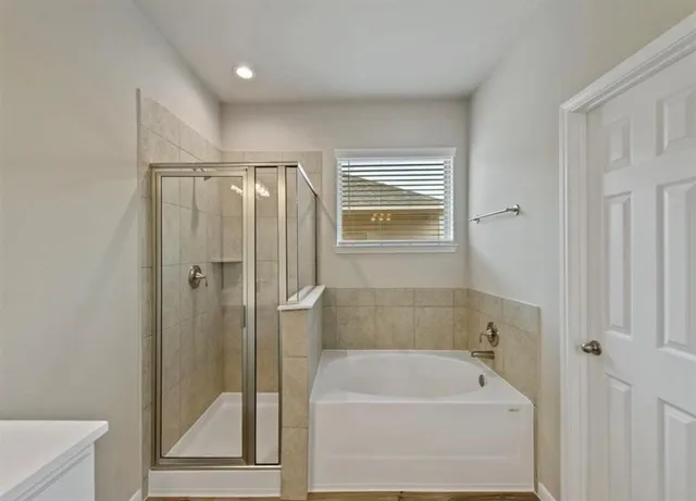 a bathroom with a tub a sink and a shower