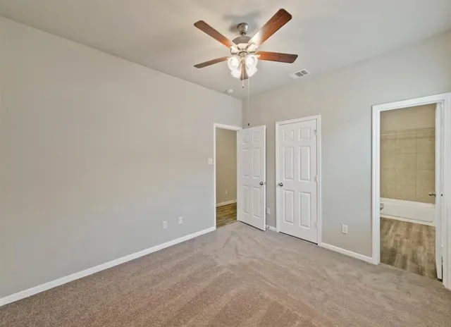 an empty room with a ceiling fan and a window