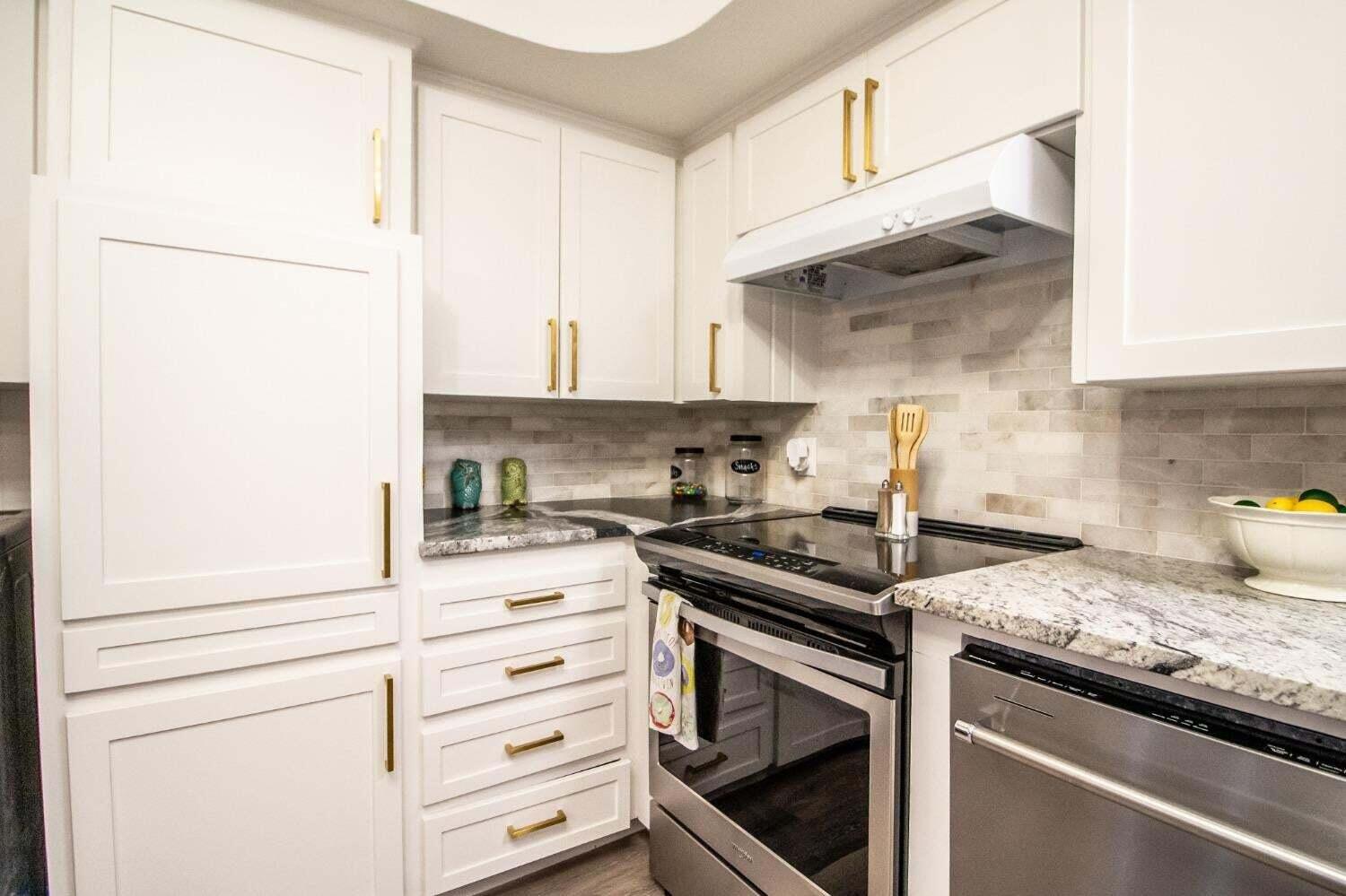 3501 33rd Street Lubbock, TX 79410 - Photo 12 of 34 a kitchen with granite countertop white cabinets and white appliances