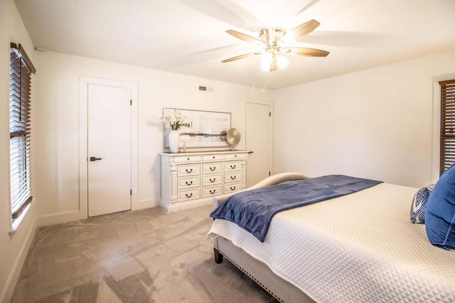 3501 33rd Street Lubbock, TX 79410 - Photo 15 of 34 a bedroom with a bed and a chandelier