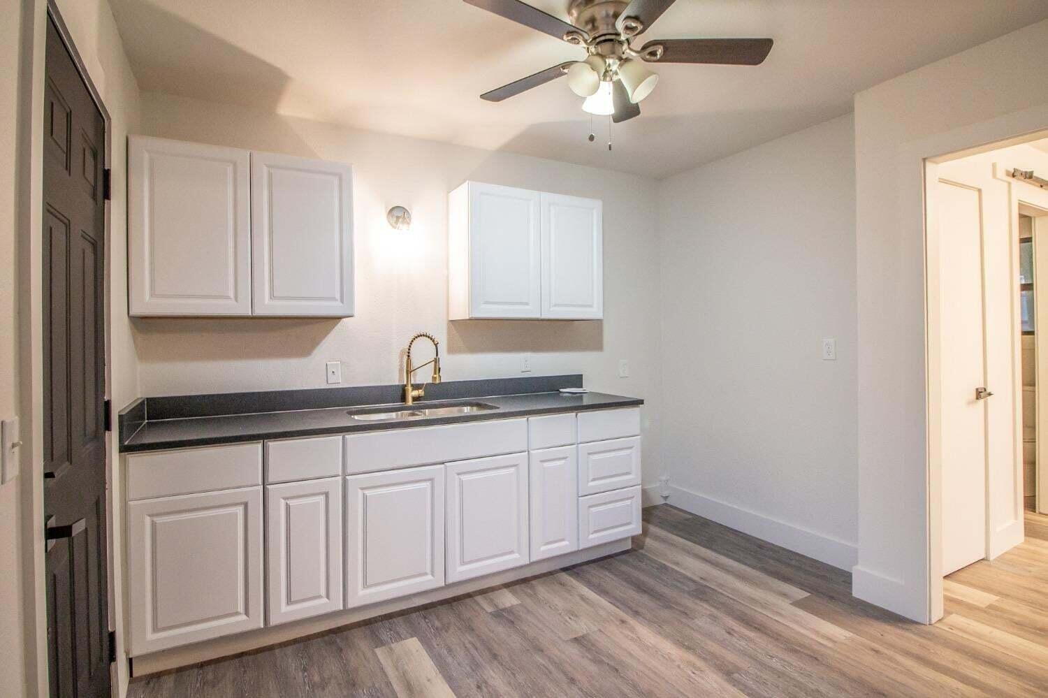 3501 33rd Street Lubbock, TX 79410 - Photo 33 of 34 a kitchen with granite countertop white cabinets and a sink